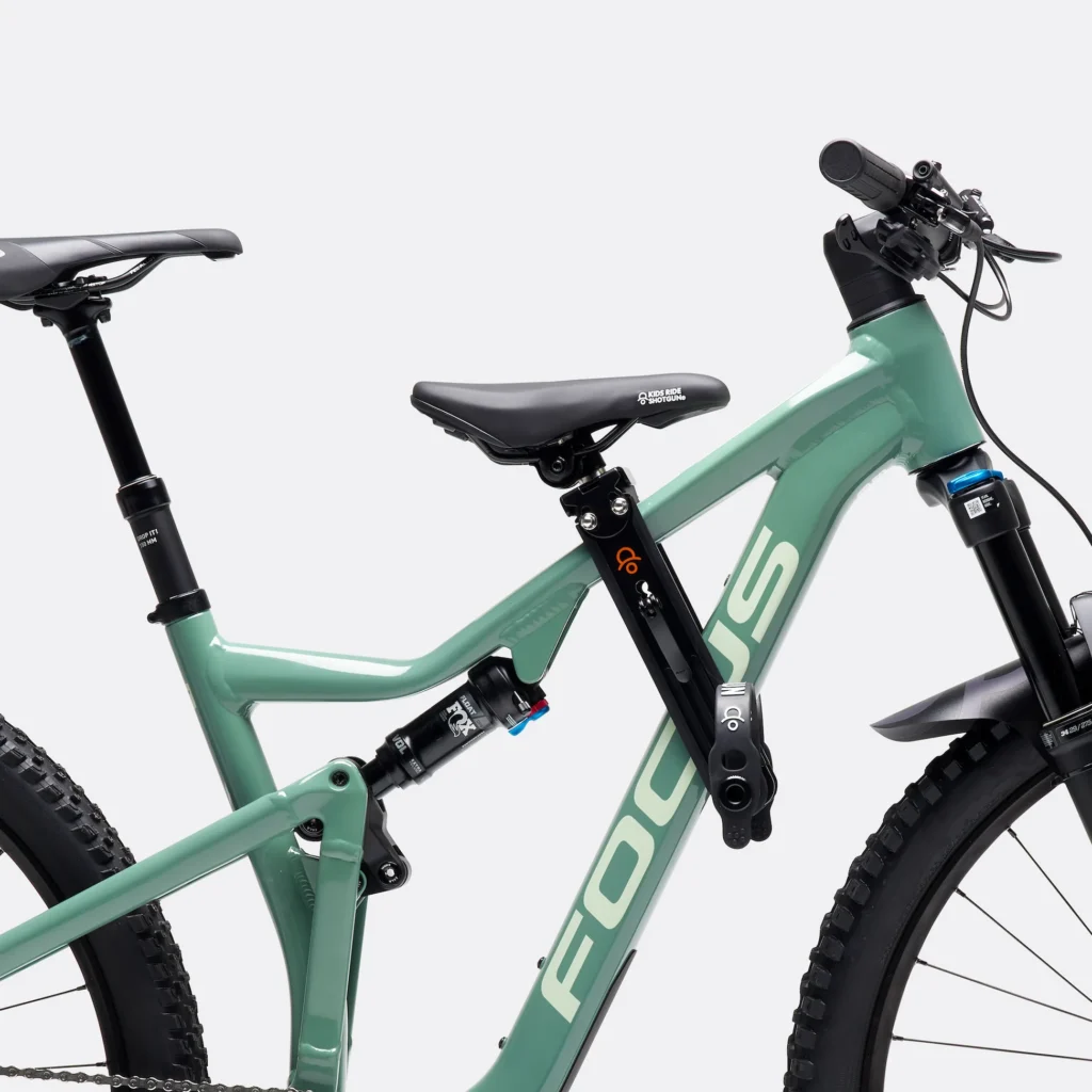 green full suspension bike close-up with a small kids seat attachment on the top tube