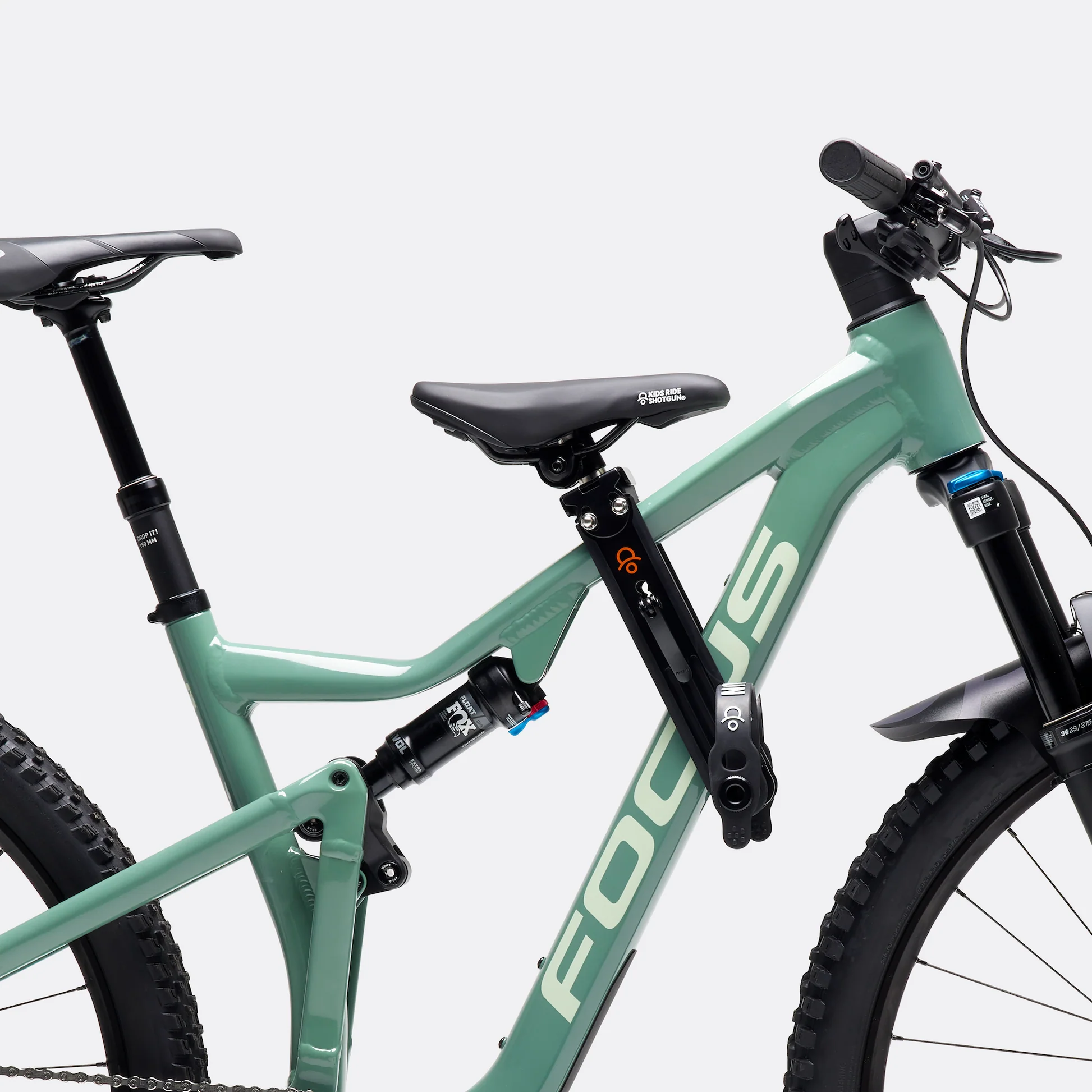 green full suspension bike close-up with a small kids seat attachment on the top tube